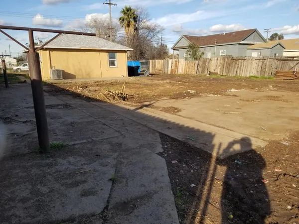 a view of a dirt road and a building in the background