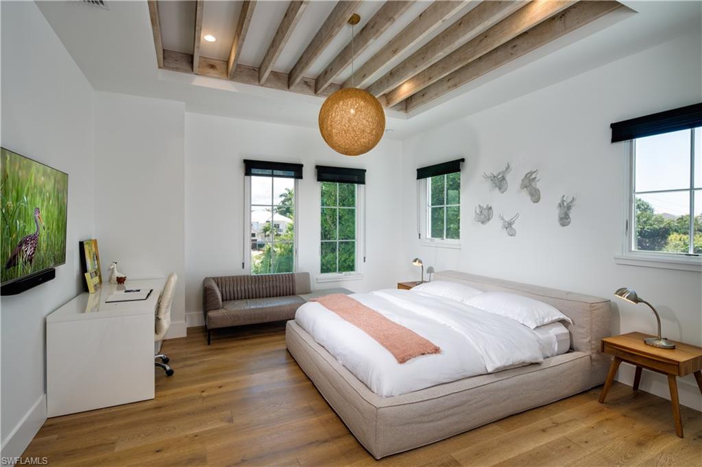 3770 Crayton Road Naples, FL 34103 - Photo 20 of 26 a bedroom with a bed mirror and window