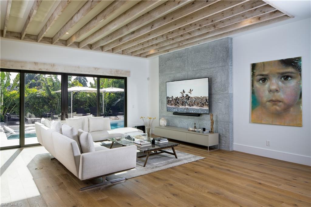 3770 Crayton Road Naples, FL 34103 - Photo 3 of 26 a living room with furniture a wooden floor and a large window