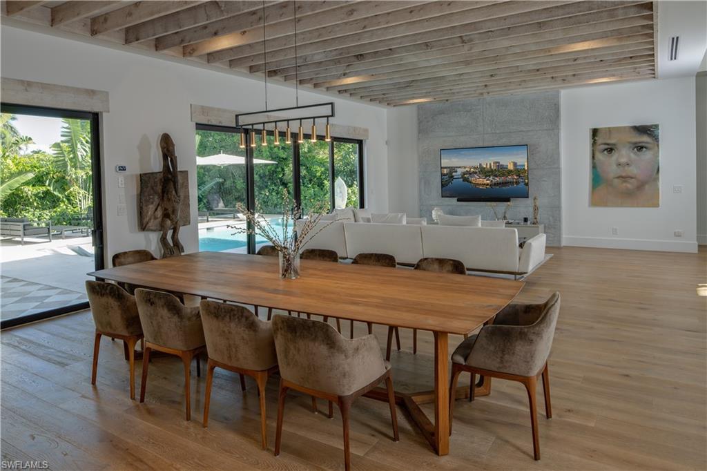 3770 Crayton Road Naples, FL 34103 - Photo 4 of 26 a dining room with furniture window and wooden floor