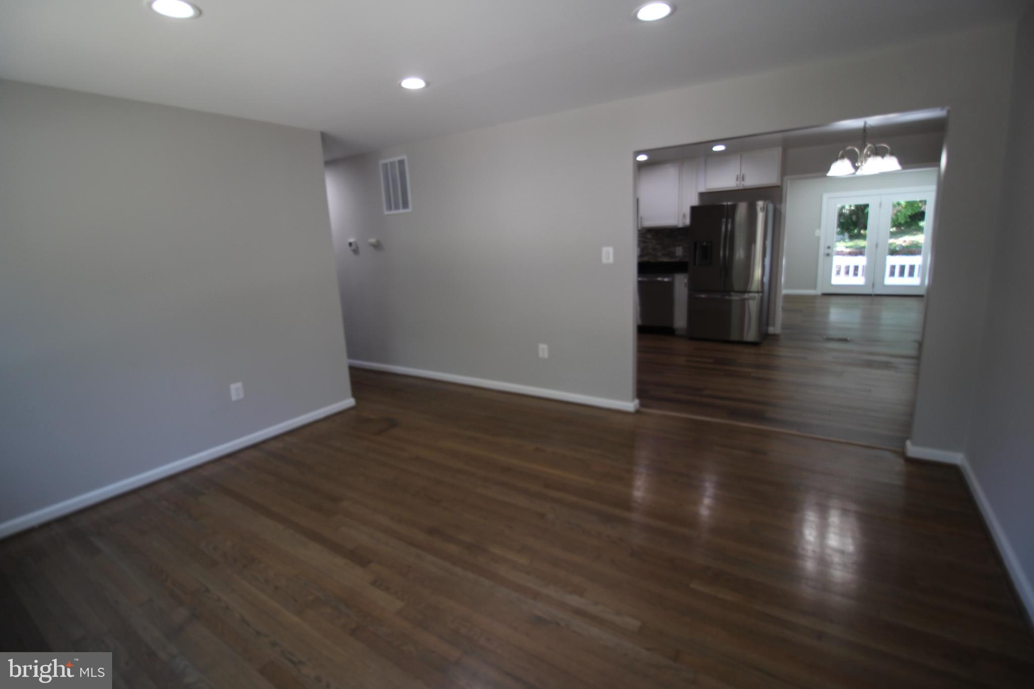 9003 Anna Drive Clinton, MD 20735 - Photo 13 of 41 a view of a hallway with wooden floor and a kitchen