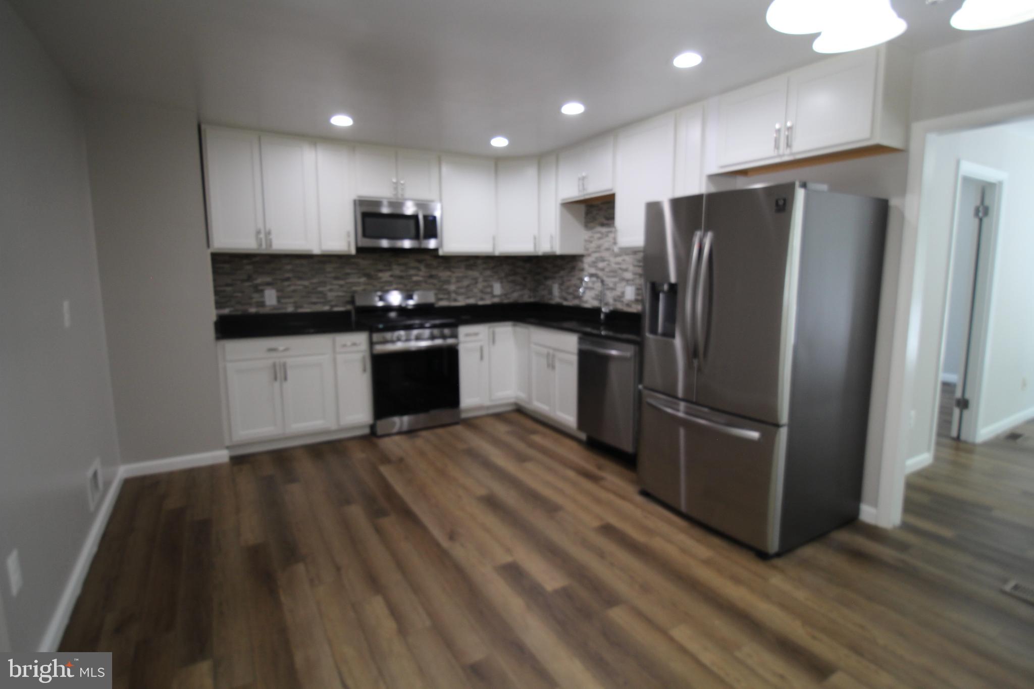 9003 Anna Drive Clinton, MD 20735 - Photo 15 of 41 a kitchen with granite countertop stainless steel appliances a sink and refrigerator