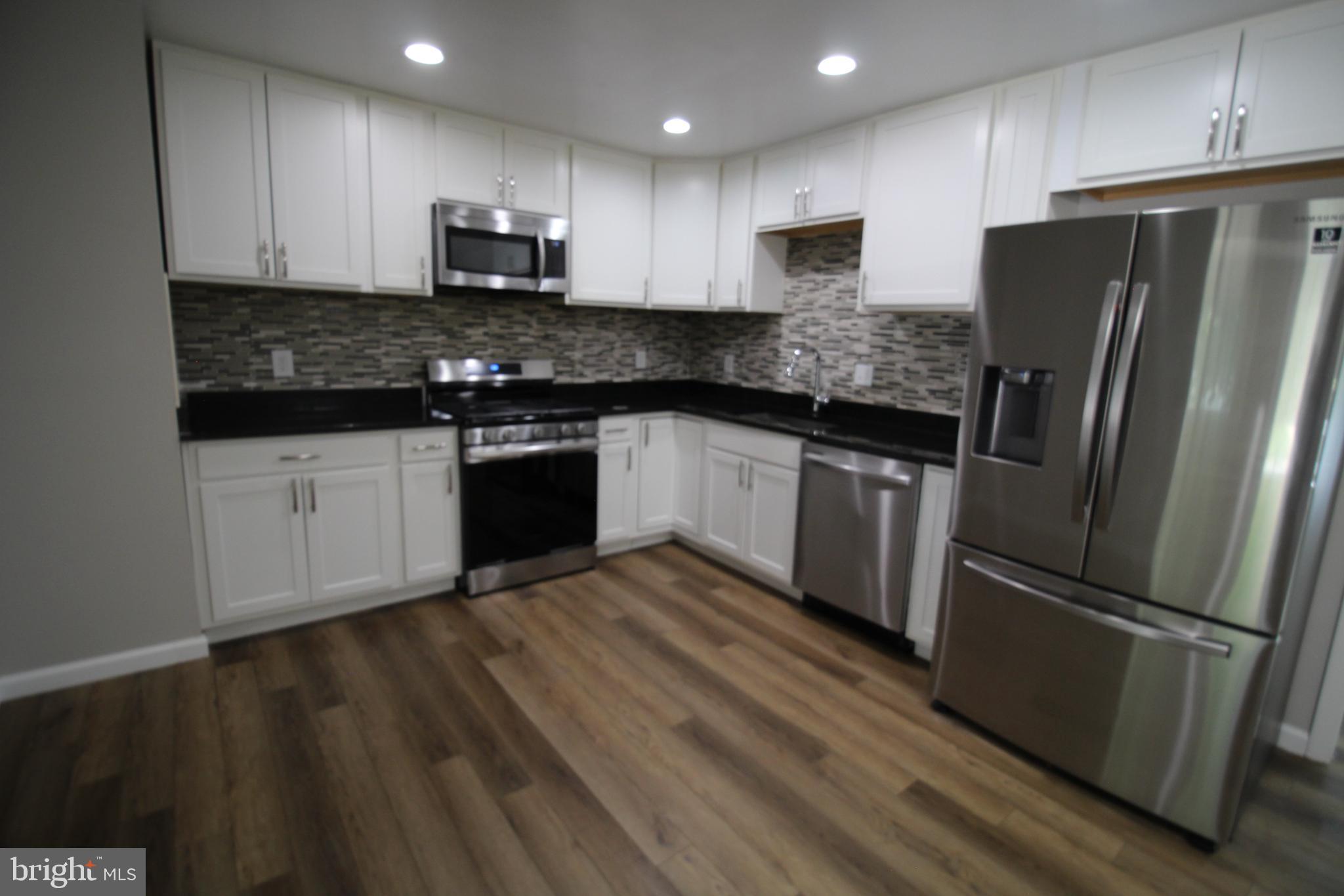 9003 Anna Drive Clinton, MD 20735 - Photo 16 of 41 a kitchen with granite countertop a refrigerator stove top oven and sink