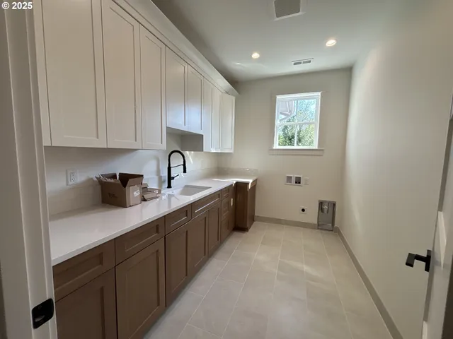 a kitchen with a sink cabinets and window