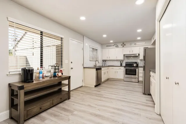 a kitchen with stainless steel appliances kitchen island granite countertop a refrigerator and cabinets