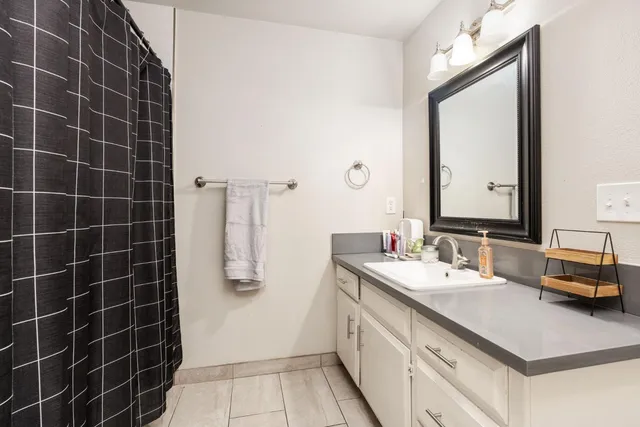 a bathroom with a double vanity sink a mirror and a shower