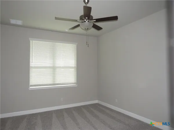 a view of a room with a window and a fan