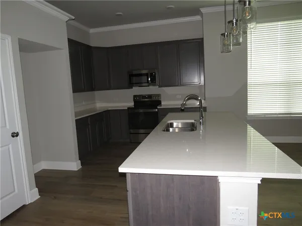 a kitchen with a sink a stove and refrigerator