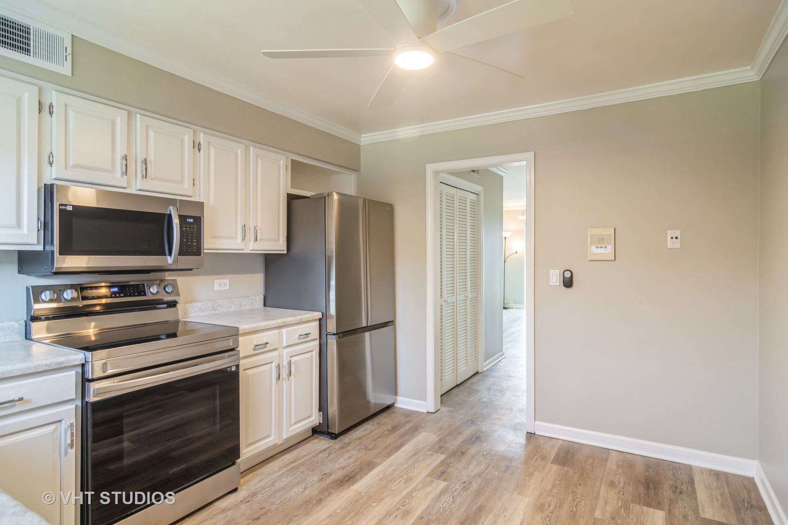 904 South Plum Grove Road, Unit 202 Palatine, IL 60067 - Photo 7 of 14 a kitchen with a refrigerator stove and white cabinets