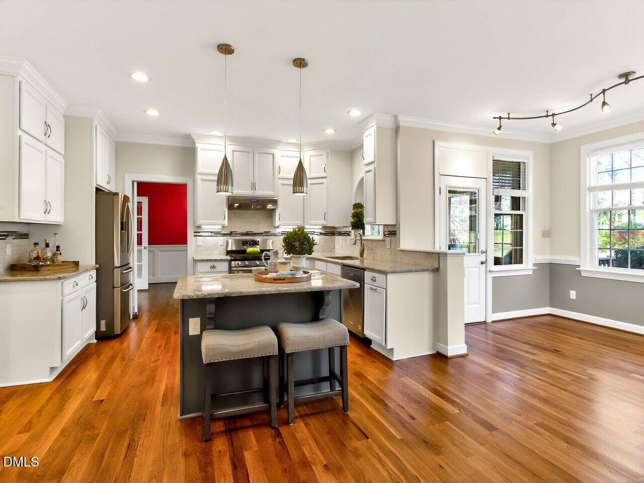 6104 Wolverhampton Drive Raleigh, NC 27603 - Photo 11 of 35 a kitchen with stainless steel appliances kitchen island granite countertop wooden floors and view living room