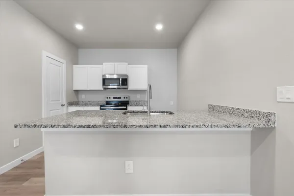 a kitchen with stainless steel appliances granite countertop a sink and cabinets
