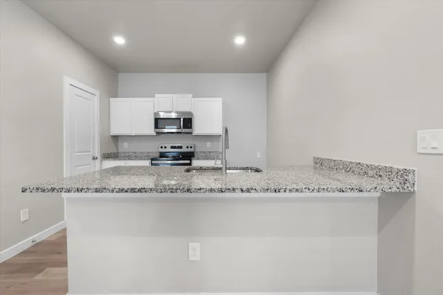 a kitchen with stainless steel appliances granite countertop a sink and cabinets