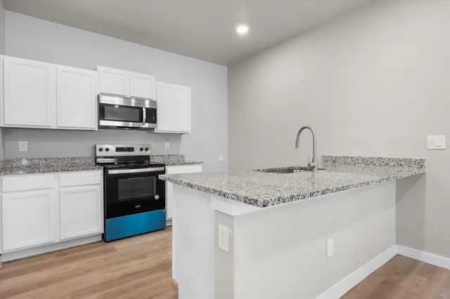 a kitchen with a sink cabinets and wooden floor