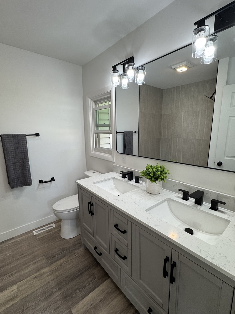 21044 Virginia Road DeKalb, IL 60115 - Photo 30 of 58 a bathroom with a double vanity sink and a toilet