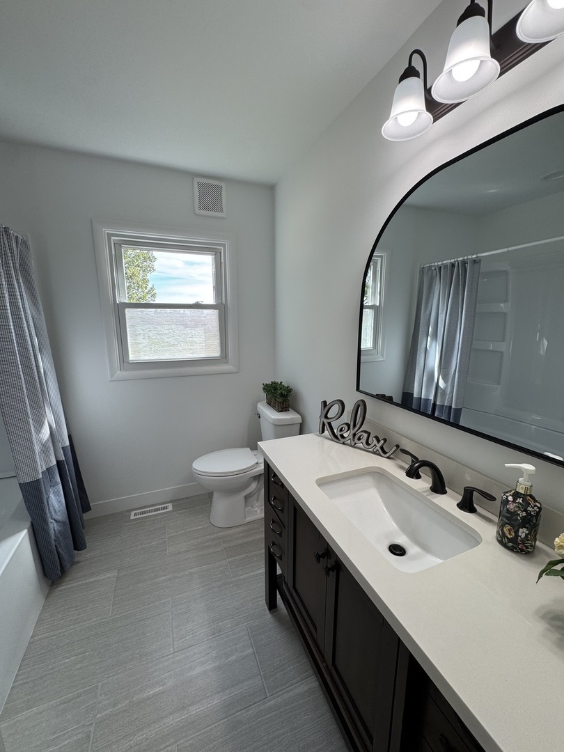 21044 Virginia Road DeKalb, IL 60115 - Photo 40 of 58 a bathroom with a sink and a mirror