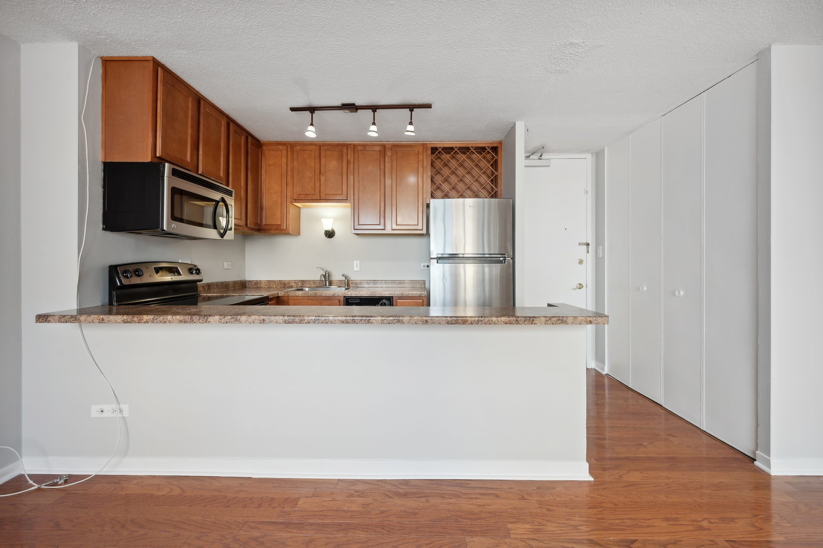 3110 North Sheridan Road, Unit 904 Chicago, IL 60657 - Photo 3 of 12 a kitchen with stainless steel appliances a refrigerator stove microwave and sink