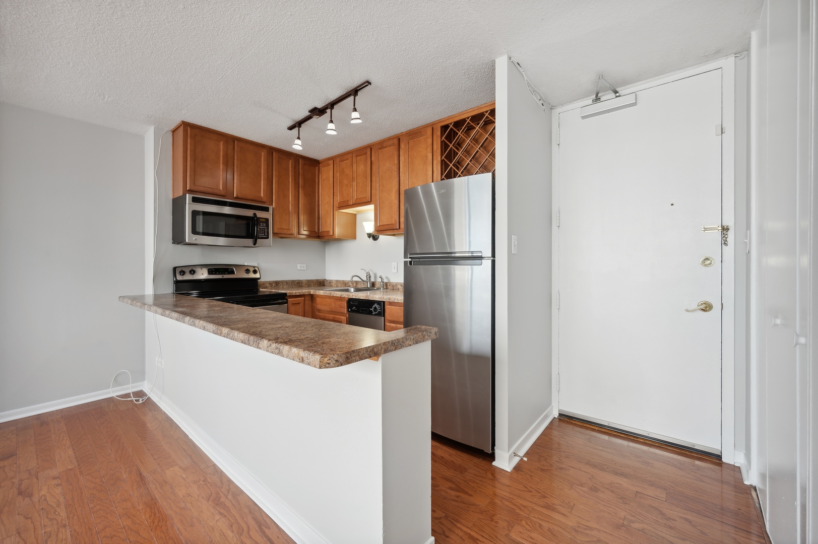 3110 North Sheridan Road, Unit 904 Chicago, IL 60657 - Photo 4 of 12 a kitchen with a refrigerator a stove top oven a sink and dishwasher