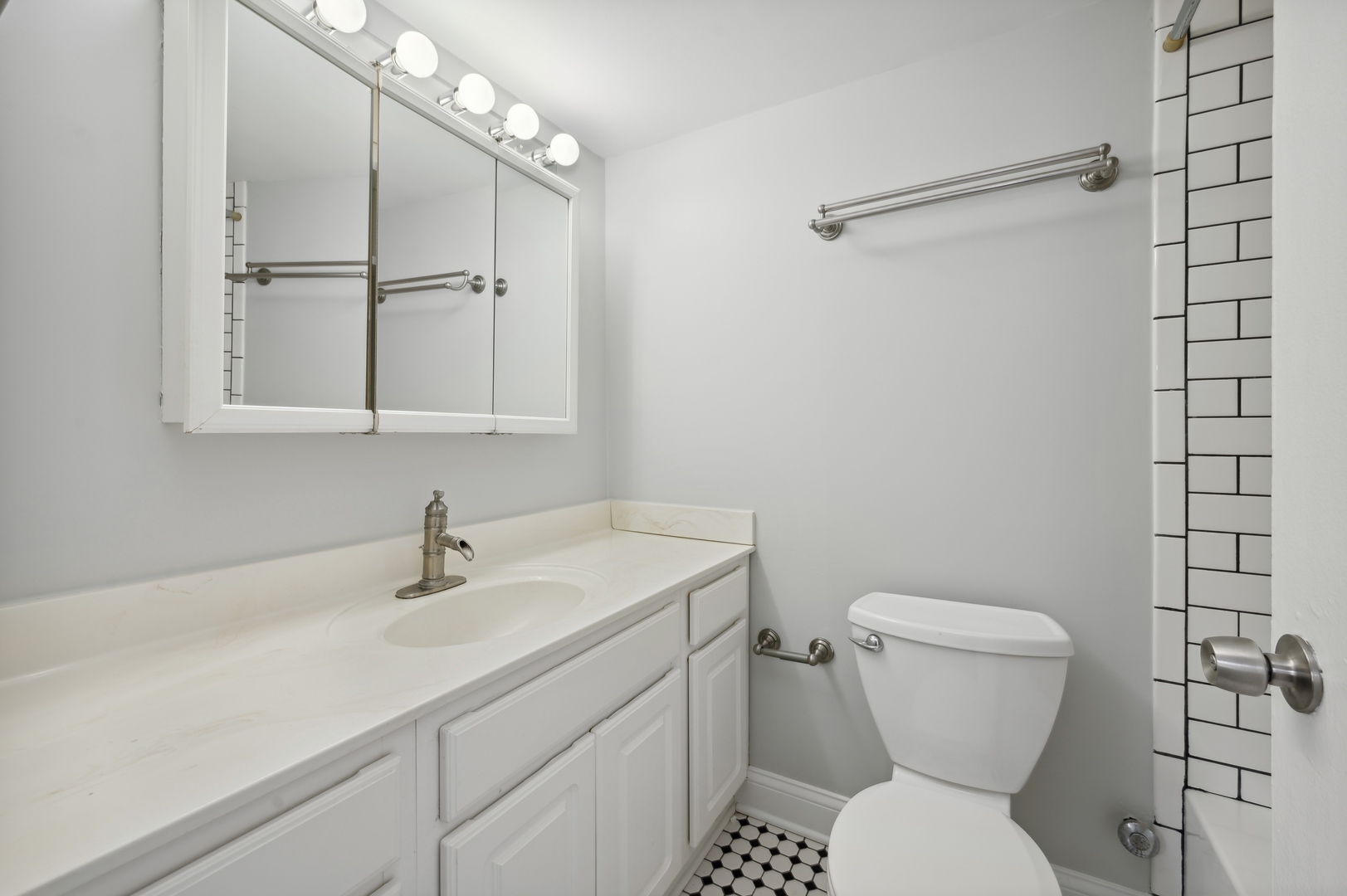 3110 North Sheridan Road, Unit 904 Chicago, IL 60657 - Photo 10 of 12 a bathroom with a toilet sink and mirror