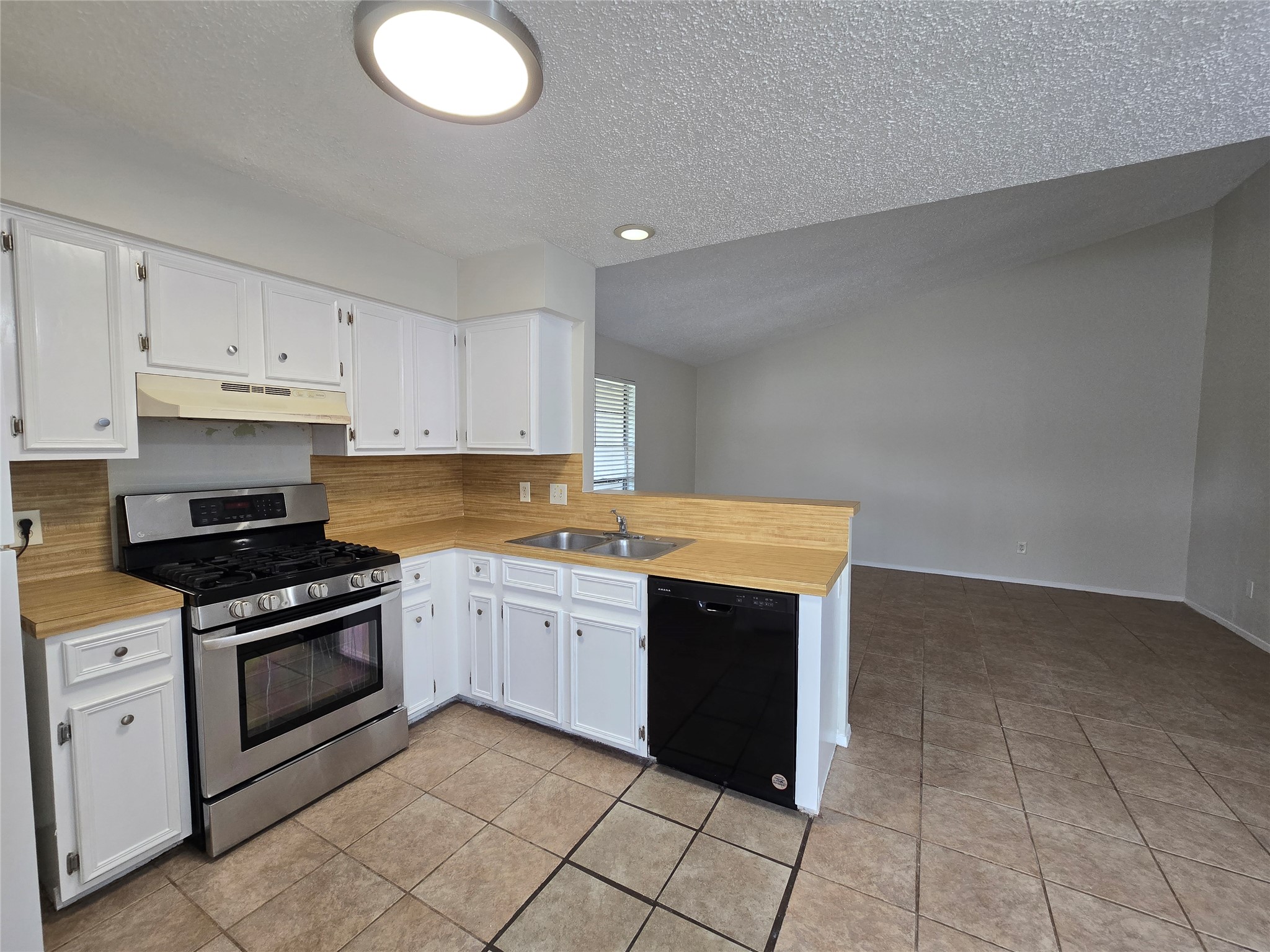 6206 Buffalo Pass, Unit A Austin, TX 78745 - Photo 24 of 24 A well-appointed kitchen features a gas range and dishwasher, alongside white cabinetry and an inviting open floorplan.