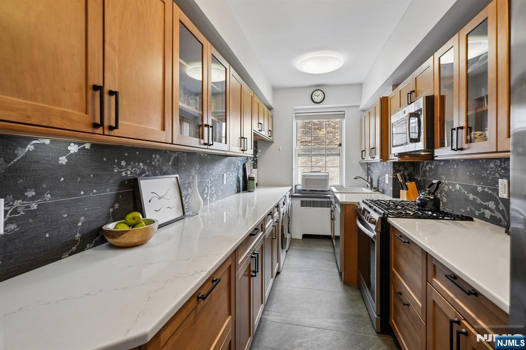 10 Crestmont Road, Unit 5J Montclair, NJ 07042 - Photo 6 of 21 a kitchen with stainless steel appliances granite countertop a sink a stove and cabinets