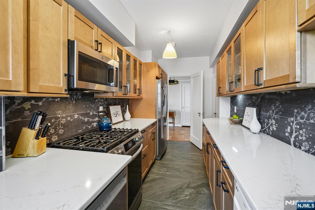 10 Crestmont Road, Unit 5J Montclair, NJ 07042 - Photo 8 of 21 a kitchen with stainless steel appliances a stove a sink a microwave a refrigerator and cabinets