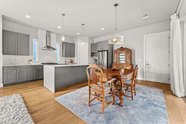 a view of a dining room and a kitchen with furniture window and wooden floor