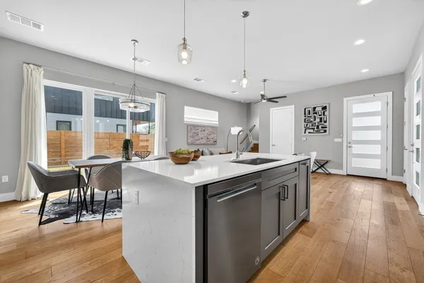 a kitchen with a stove a window and chairs