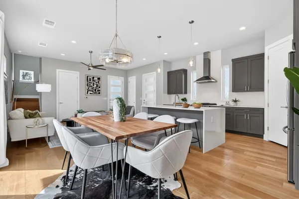 a kitchen with stainless steel appliances kitchen island granite countertop a dining table chairs and sink