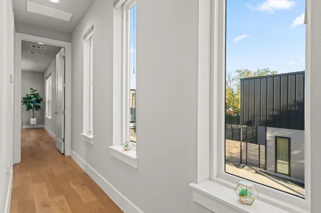 a view of a hallway with wooden floor and staircase