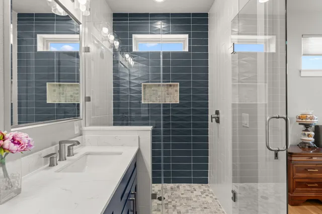 a bathroom with a sink shower and a mirror