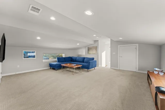 an empty room with furniture and a flat screen tv