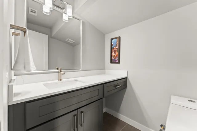 a bathroom with a sink a mirror and a toilet