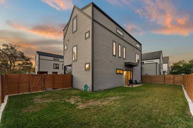 a view of backyard of house with wooden fence