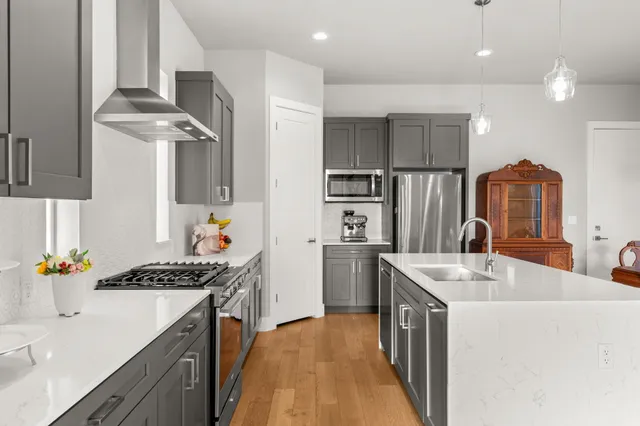 a kitchen with stainless steel appliances granite countertop a sink stove and refrigerator
