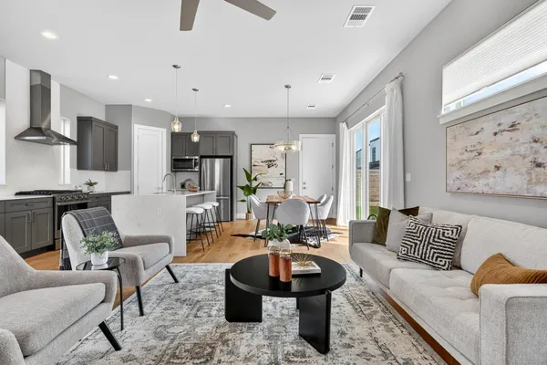 a living room with furniture and a view of kitchen