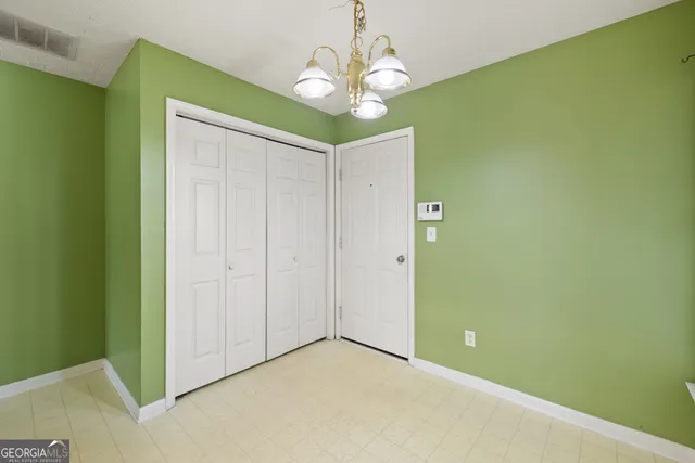 a view of an empty room with a chandelier fan