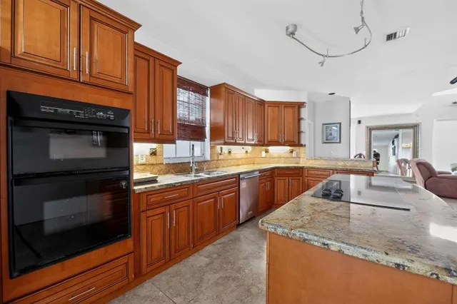 a kitchen with stainless steel appliances granite countertop a stove sink and cabinets