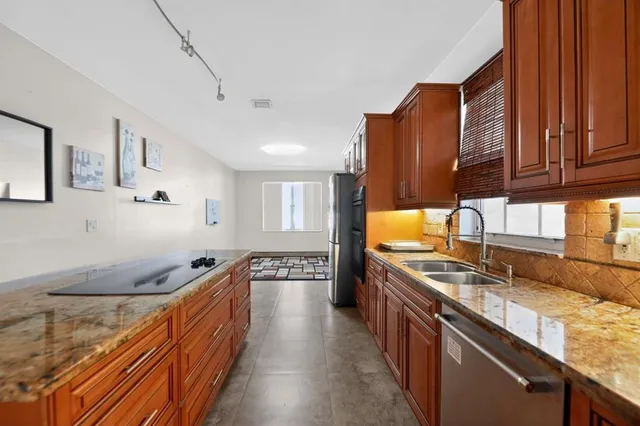 a kitchen with stainless steel appliances granite countertop a sink stove and cabinets