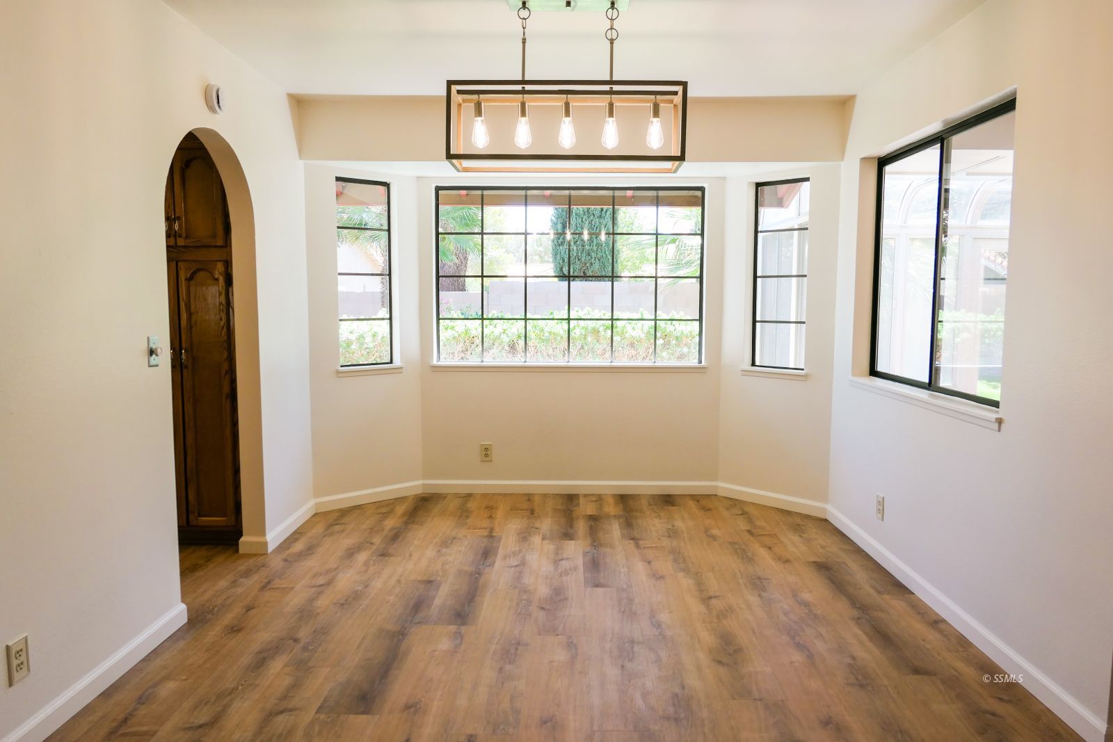 925 Hermosa Avenue Ridgecrest, CA 93555 - Photo 7 of 50 an empty room with wooden floor and windows