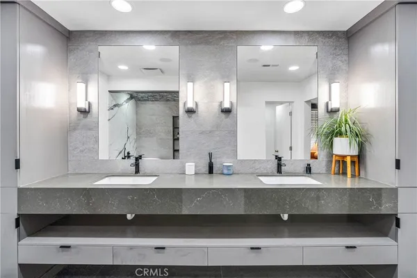 a bathroom with double vanity sinks and a mirror