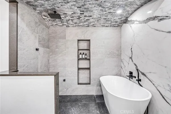 a bathroom with a sink and mirror with bathtub
