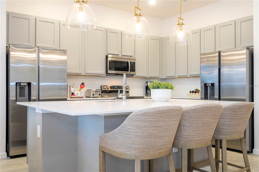 5887 High Seas Drive Orlando, FL 32821 - Photo 12 of 93 a kitchen with kitchen island granite countertop a sink refrigerator and microwave