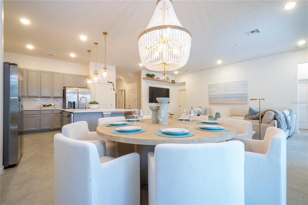 5887 High Seas Drive Orlando, FL 32821 - Photo 14 of 93 a kitchen with stainless steel appliances kitchen island granite countertop a sink a stove a dining table and chairs