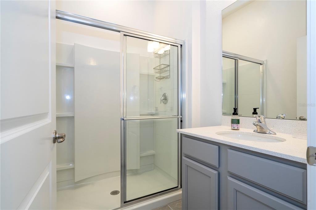 5887 High Seas Drive Orlando, FL 32821 - Photo 32 of 93 a bathroom with a shower sink and mirror