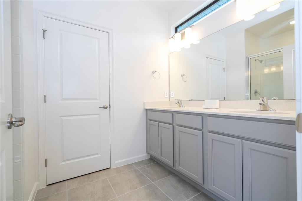 5887 High Seas Drive Orlando, FL 32821 - Photo 48 of 93 a bathroom with a double vanity sink and mirror