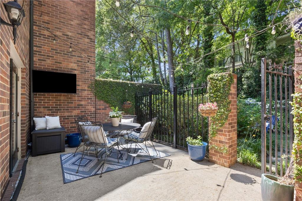 26 Howell Mill Road Northwest Atlanta, GA 30327 - Photo 24 of 33 a view of a patio with couches table and chairs with potted plants and large trees