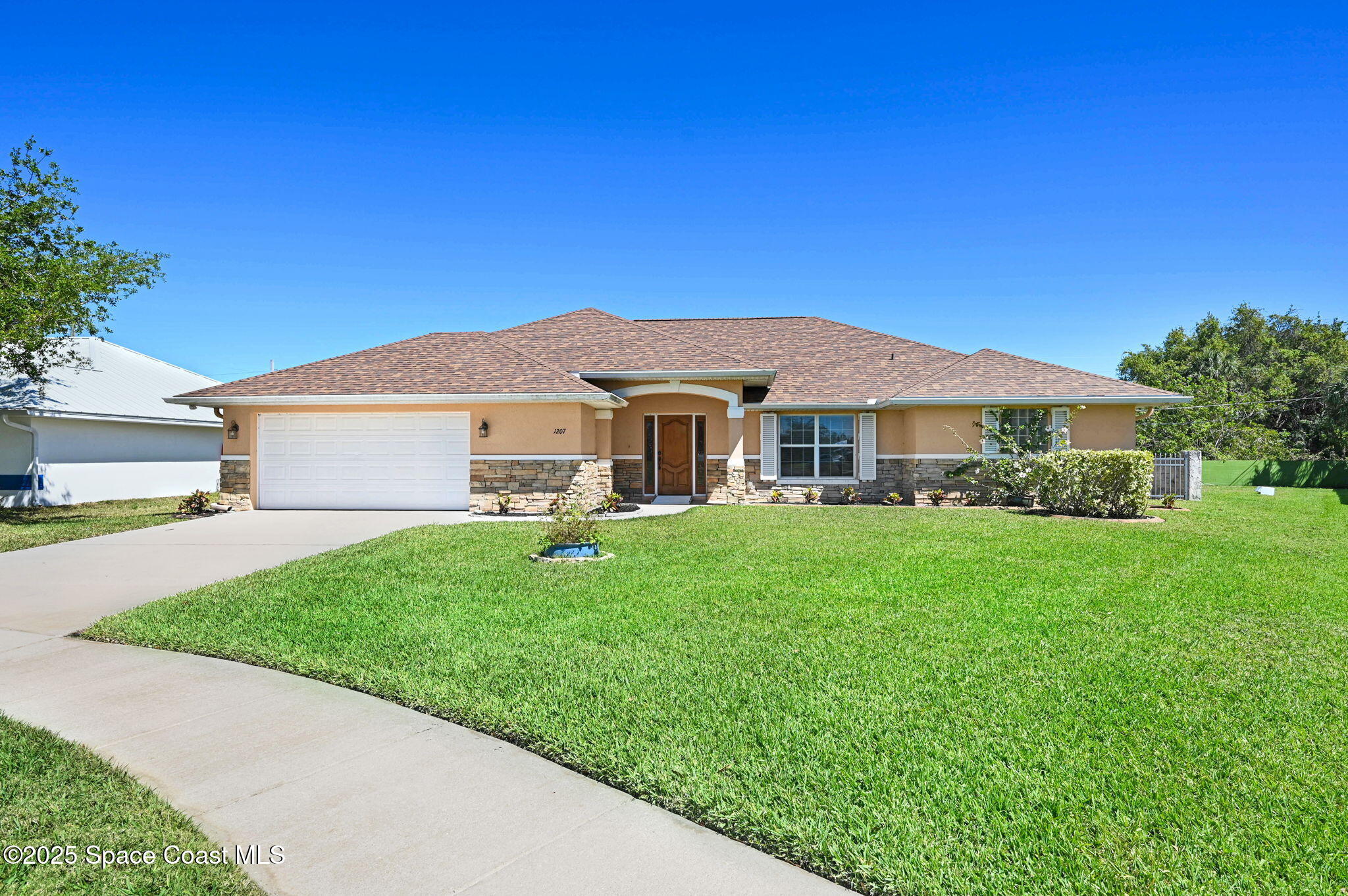 1207 Van Tassel Trail Palm Bay, FL 32905 - Photo 1 of 28 a view of a yard in front of a house with plants and large tree