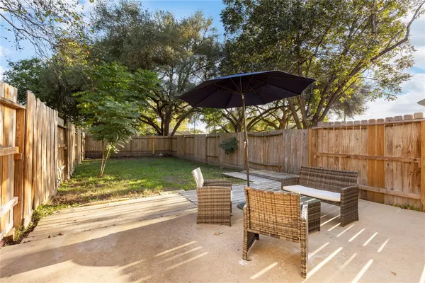 a view of backyard with wooden fence and a large tree