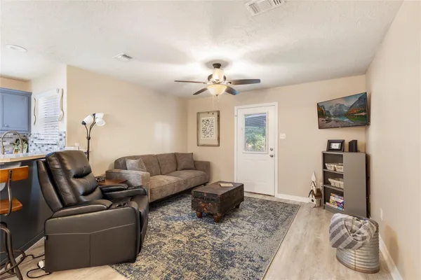 a living room with furniture a flat screen tv and a window