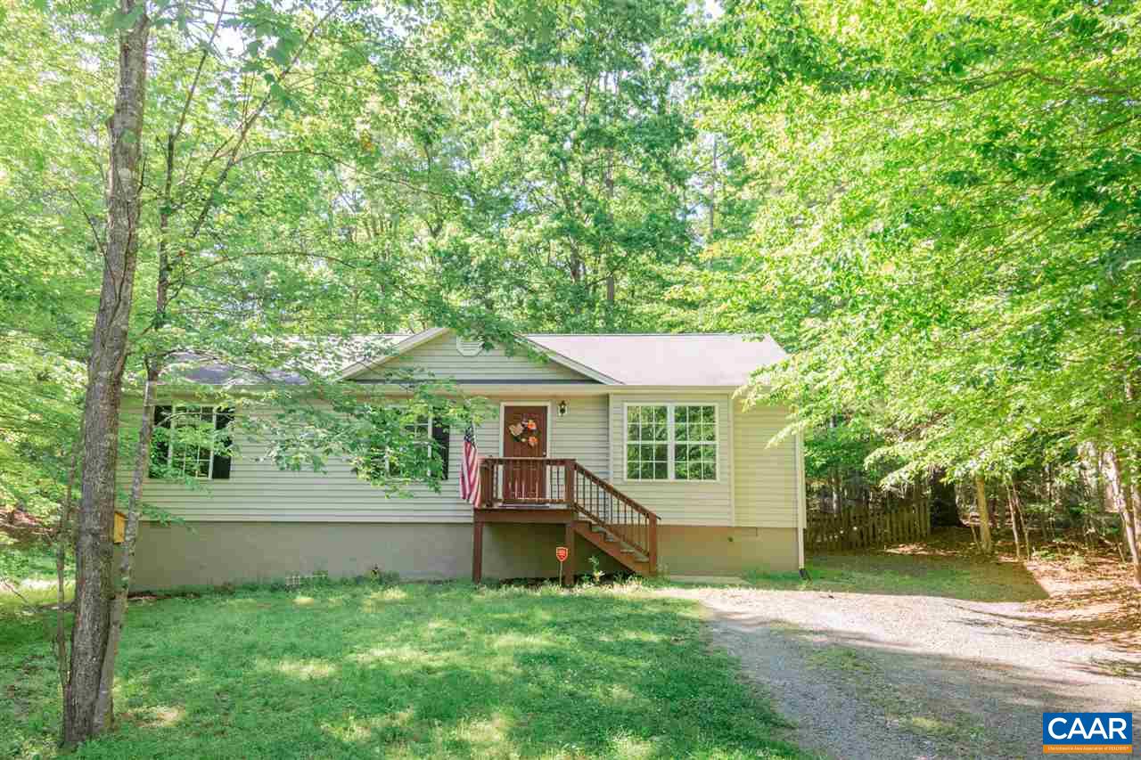 a view of a house with a yard and a large tree